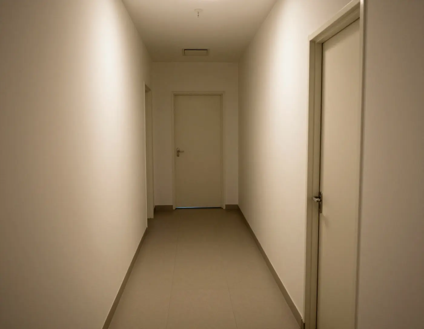 Couloir sobre d'un bâtiment funéraire avec portes claires et lumière tamisée